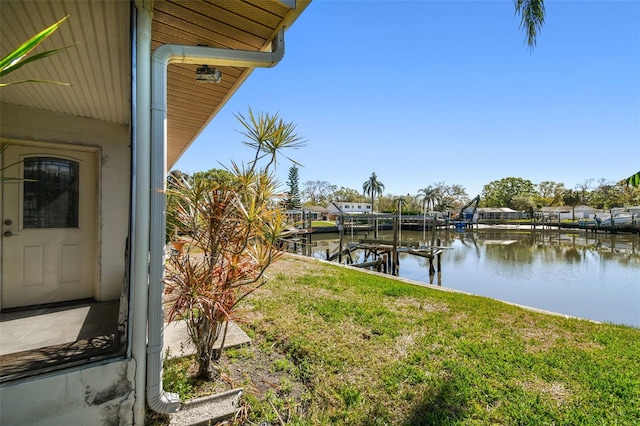 view of dock featuring a yard, a water view, and boat lift