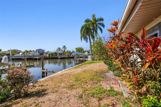 view of yard featuring a boat dock and a water view