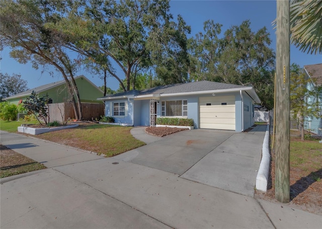 single story home featuring a front lawn, fence, concrete driveway, stucco siding, and an attached garage