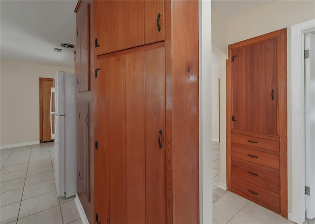 hallway with light tile patterned floors and baseboards