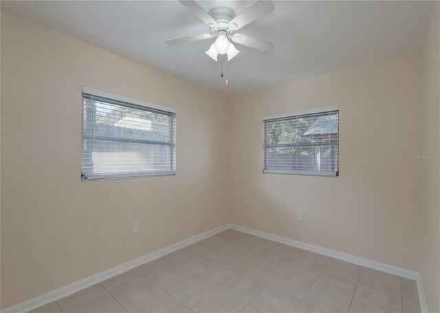 empty room featuring light tile patterned floors, baseboards, and ceiling fan