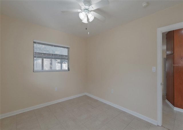 spare room featuring light tile patterned flooring, baseboards, and a ceiling fan