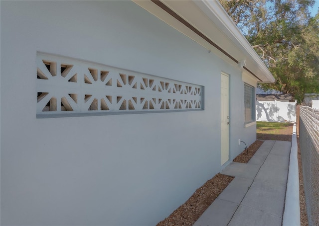 exterior space with stucco siding and fence