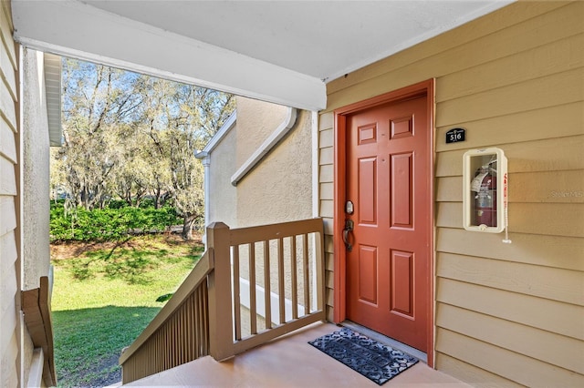 view of exterior entry with a lawn