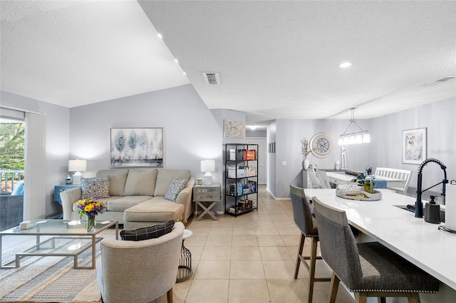 living area featuring light tile patterned floors, visible vents, and a textured ceiling