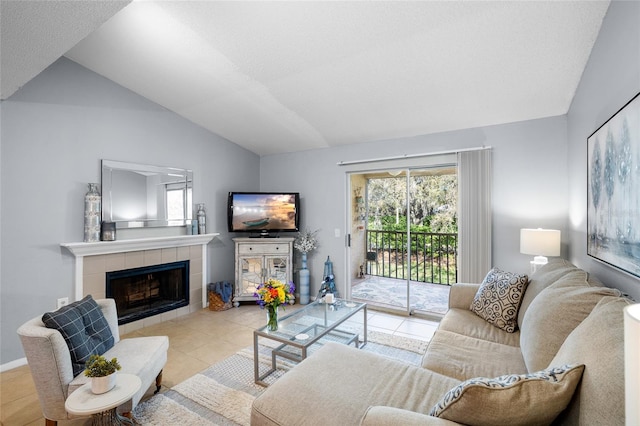 tiled living area featuring lofted ceiling and a tile fireplace