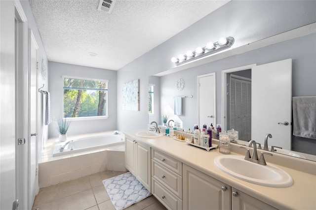 full bathroom featuring tile patterned flooring, visible vents, a garden tub, and a sink