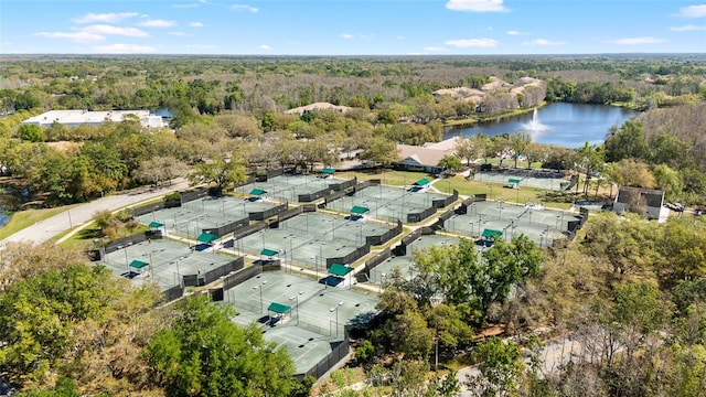 drone / aerial view featuring a wooded view and a water view