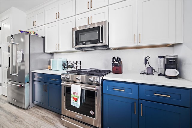 kitchen featuring light countertops, blue cabinets, light wood-style floors, and appliances with stainless steel finishes