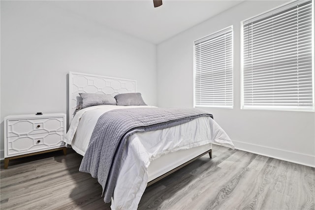 bedroom with wood finished floors, baseboards, and ceiling fan