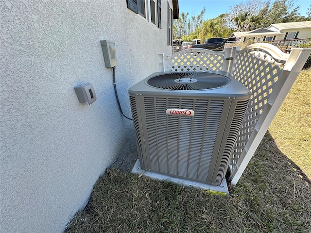 details featuring stucco siding and cooling unit