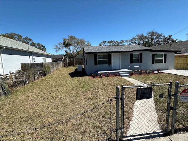 view of front of home featuring a front lawn, a gate, a fenced front yard, and stucco siding