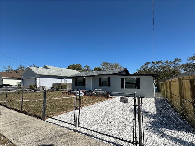 view of front of home featuring a fenced front yard, stucco siding, and a gate