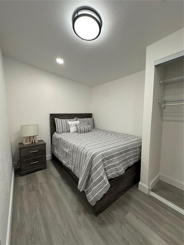 bedroom with recessed lighting, baseboards, a textured ceiling, and wood finished floors