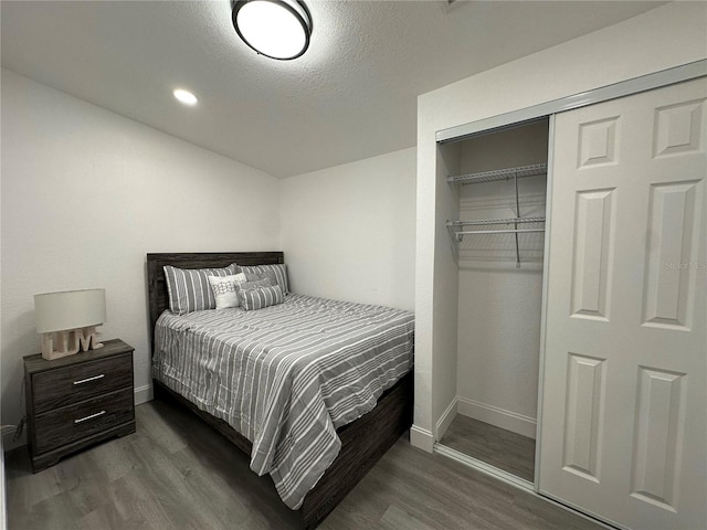 bedroom featuring a textured ceiling, dark wood finished floors, recessed lighting, a closet, and baseboards