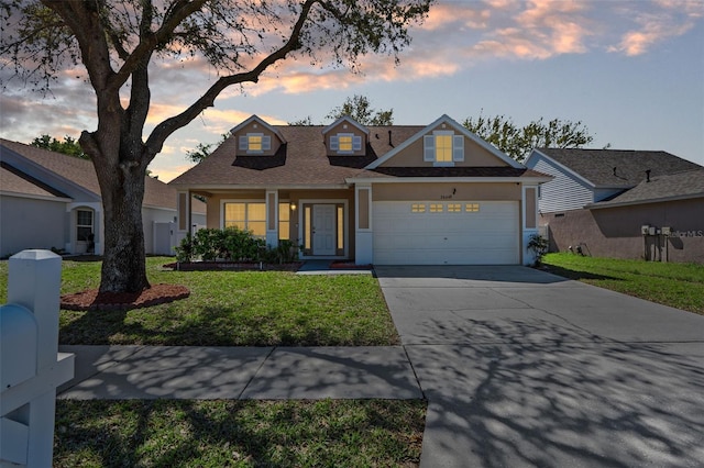 view of front of property featuring roof with shingles, an attached garage, stucco siding, concrete driveway, and a lawn