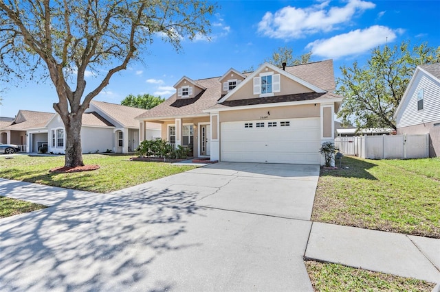 view of front of property with stucco siding, concrete driveway, a front yard, and fence