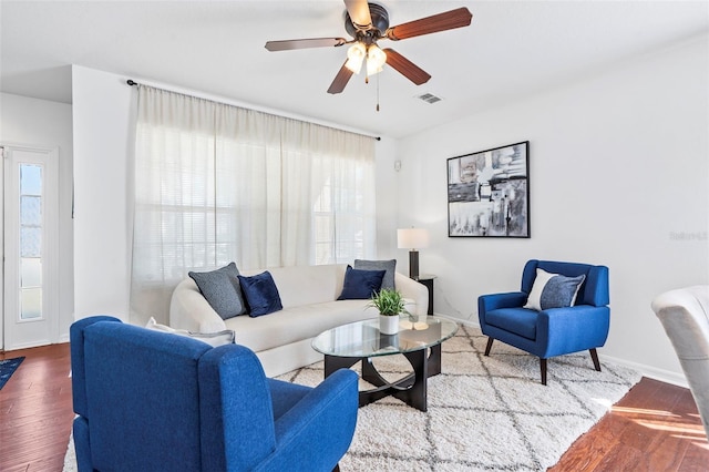 living room with ceiling fan, plenty of natural light, and wood finished floors