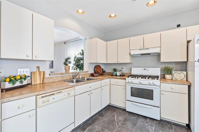 kitchen featuring under cabinet range hood, recessed lighting, marble finish floor, white appliances, and a sink