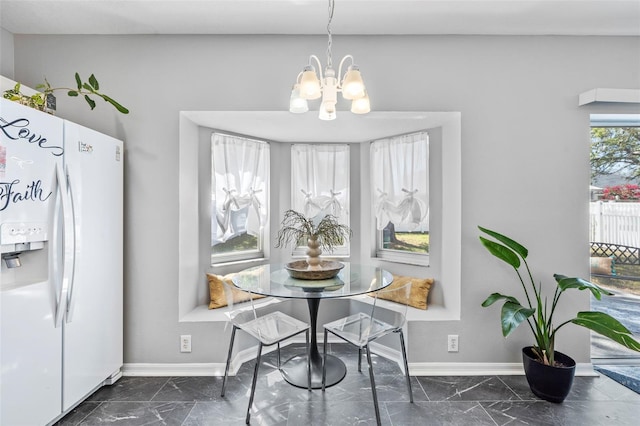 dining room featuring an inviting chandelier, baseboards, and marble finish floor