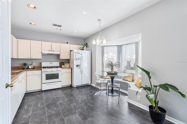 kitchen featuring visible vents, baseboards, under cabinet range hood, an inviting chandelier, and white appliances