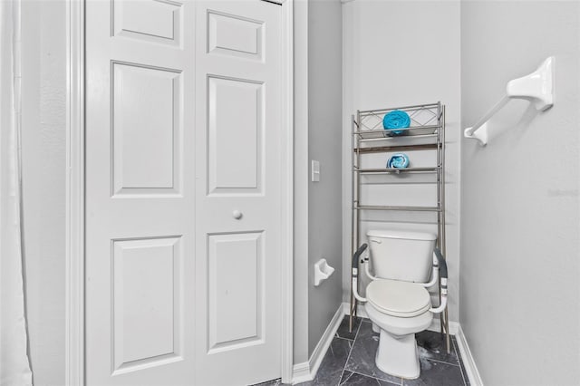 bathroom featuring baseboards and toilet