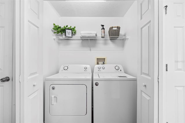 laundry room featuring laundry area, independent washer and dryer, and a textured ceiling