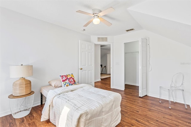 bedroom with visible vents, baseboards, wood finished floors, and vaulted ceiling