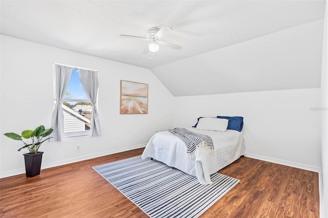 bedroom featuring baseboards, wood finished floors, a ceiling fan, and vaulted ceiling