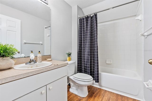 bathroom with shower / bath combo with shower curtain, toilet, vanity, wood finished floors, and a textured ceiling