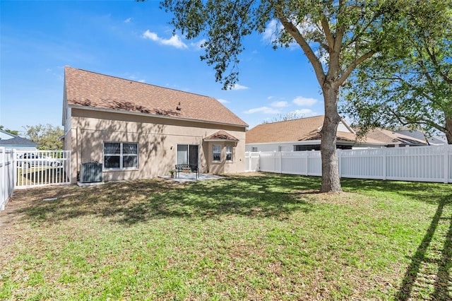 back of house with stucco siding, a lawn, central AC, and a fenced backyard