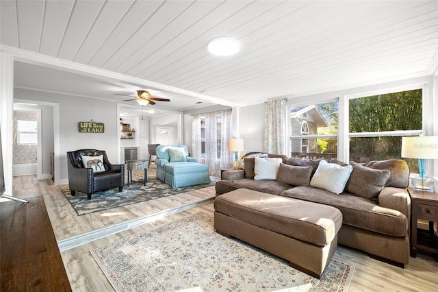 living room with ornamental molding, wood finished floors, wooden ceiling, baseboards, and ceiling fan