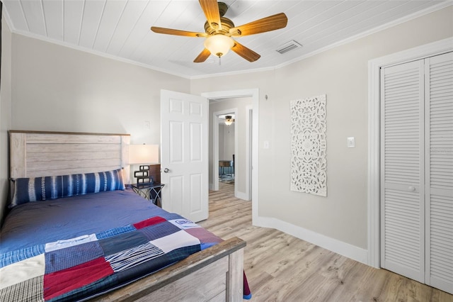 bedroom featuring baseboards, a closet, light wood finished floors, and ornamental molding