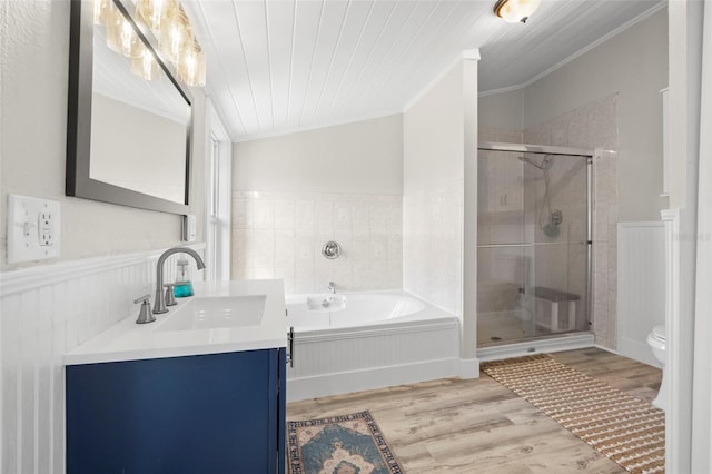 bathroom featuring a garden tub, wood finished floors, a stall shower, wainscoting, and crown molding