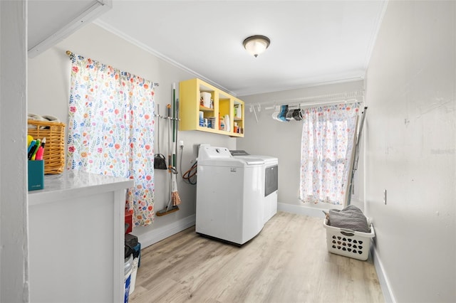 washroom with baseboards, laundry area, ornamental molding, light wood-style floors, and washing machine and dryer