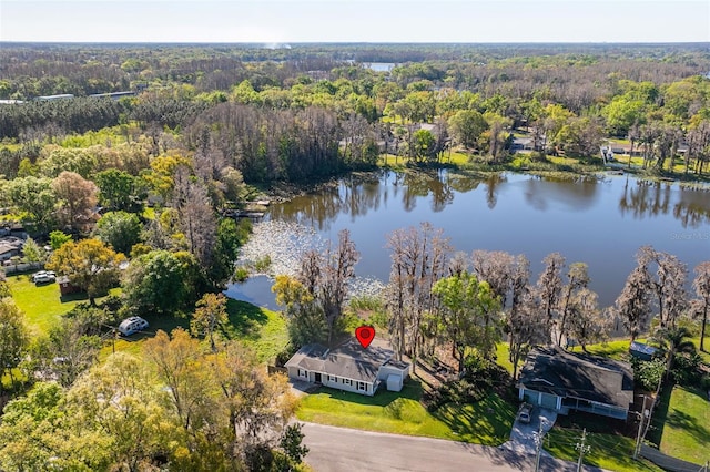 drone / aerial view with a forest view and a water view