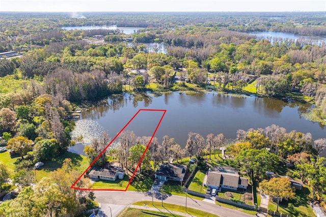 bird's eye view featuring a wooded view and a water view