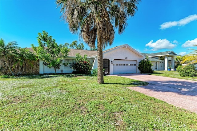 view of front of home featuring a front yard, an attached garage, driveway, and stucco siding