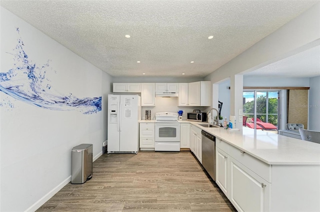 kitchen featuring light wood-style flooring, under cabinet range hood, stainless steel appliances, a peninsula, and light countertops