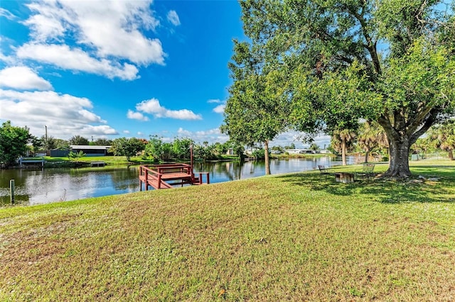 view of dock with a yard and a water view