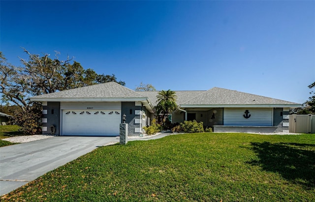 ranch-style house featuring an attached garage, concrete driveway, a front lawn, and a shingled roof