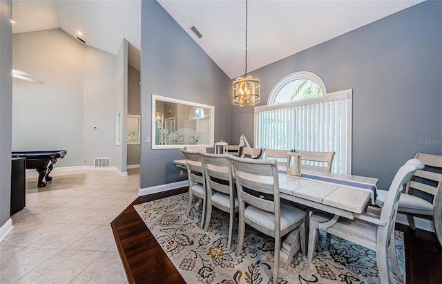 dining area with light tile patterned flooring, visible vents, high vaulted ceiling, and baseboards