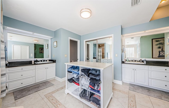 bathroom featuring tile patterned flooring, visible vents, and a sink