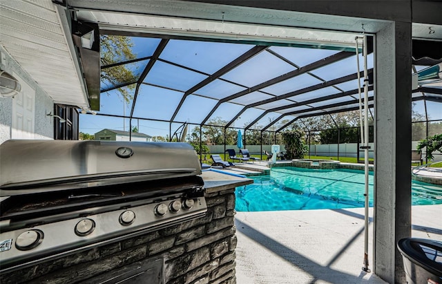 view of swimming pool with a patio, fence, an outdoor kitchen, a pool with connected hot tub, and a grill