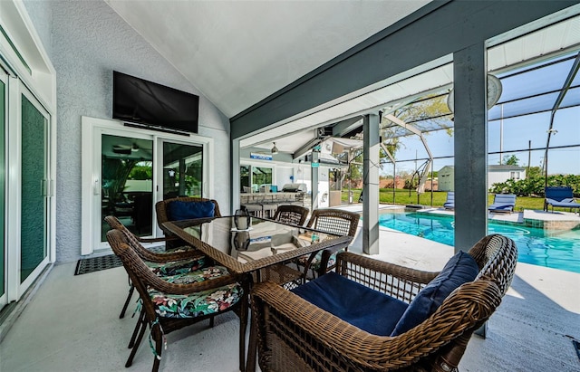 view of patio with glass enclosure, outdoor dining area, and a pool with connected hot tub