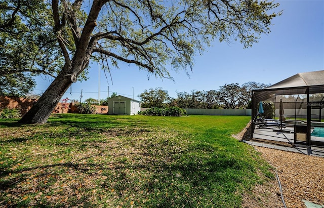 view of yard featuring a shed, a fenced backyard, an outdoor pool, an outdoor structure, and a lanai