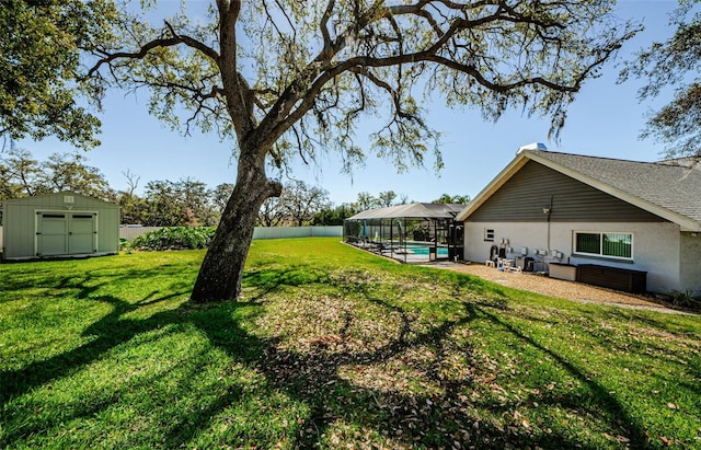 view of yard with a fenced backyard, glass enclosure, a storage shed, an outdoor structure, and an outdoor pool