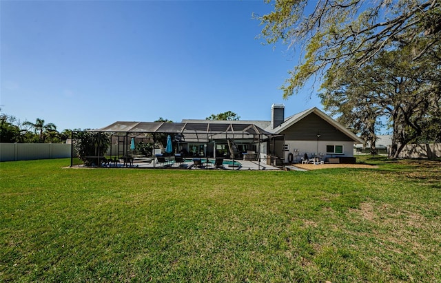 rear view of house featuring a lanai, a patio area, a lawn, and a fenced backyard