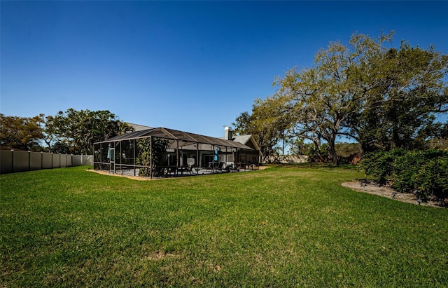 view of yard with a lanai and fence