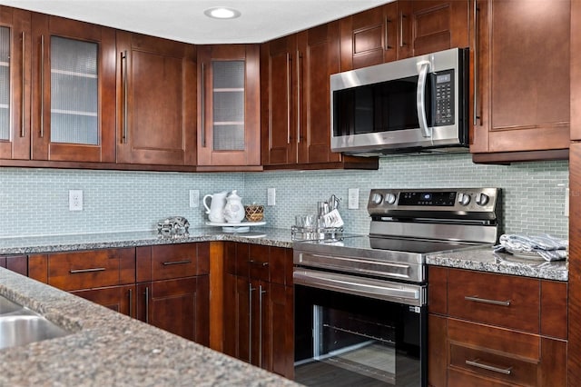 kitchen featuring light stone countertops, tasteful backsplash, and stainless steel appliances